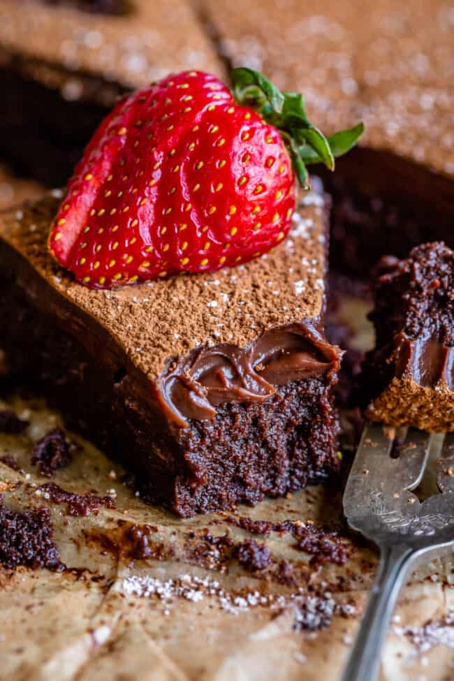 flourless chocolate cake with ganache and a strawberry on top.