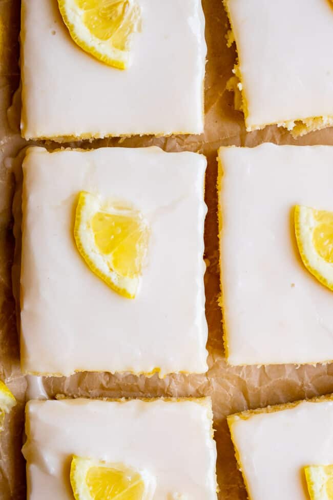 squares of lemon sheet cake, glazed, with lemon slices.