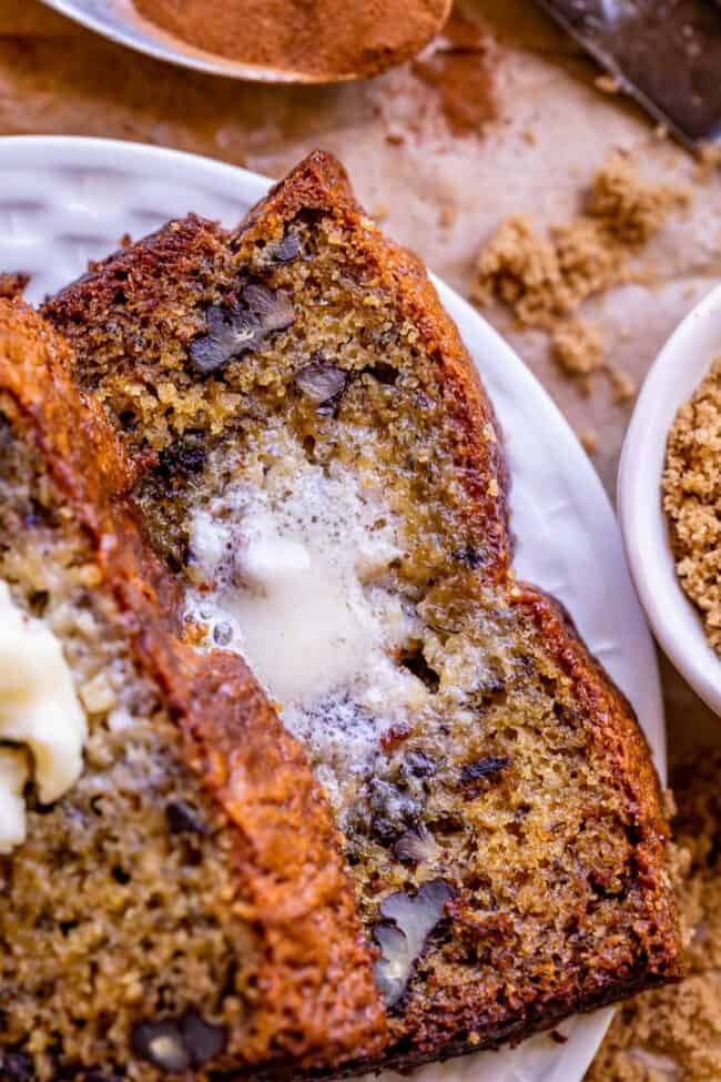 butter melting on a slice of moist banana bread with walnuts.