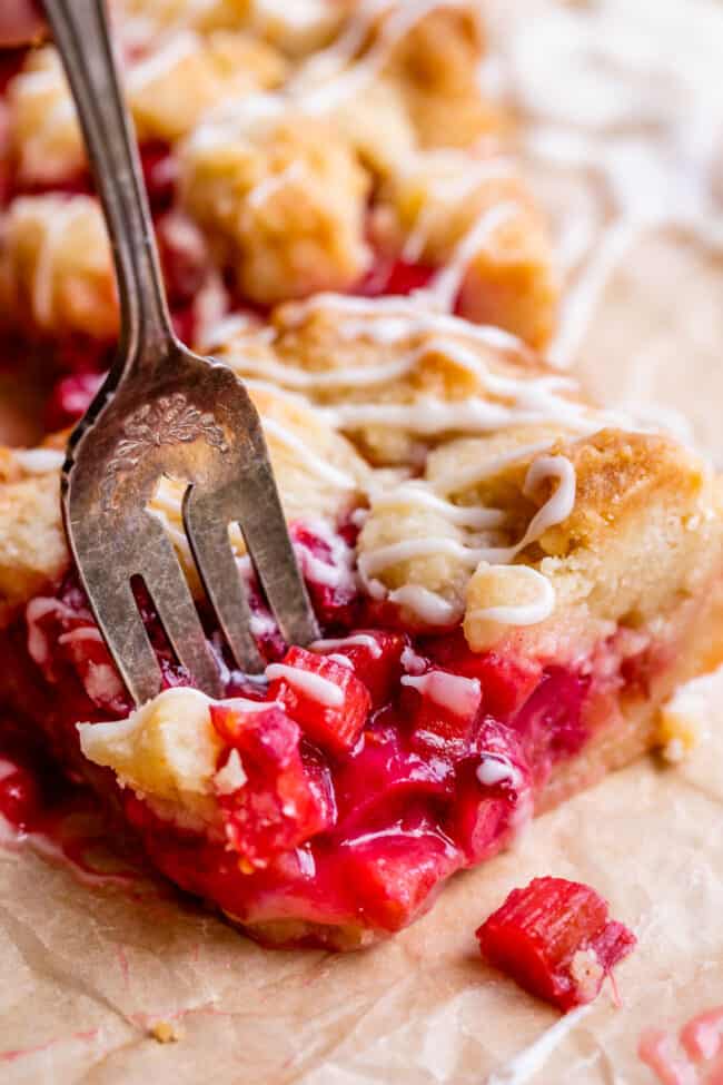 fork slicing into rhubarb crumble bars with shortbread pastry