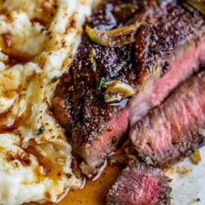 how to cook steak slices next to mashed potatoes, all drizzled with gravy