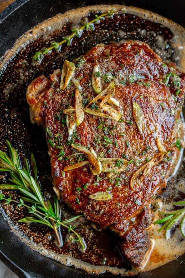 cook ribeye steak in a cast iron pan with garlic butter and rosemary.