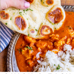 dipping homemade naan into chicken tikka masala with a side of rice.