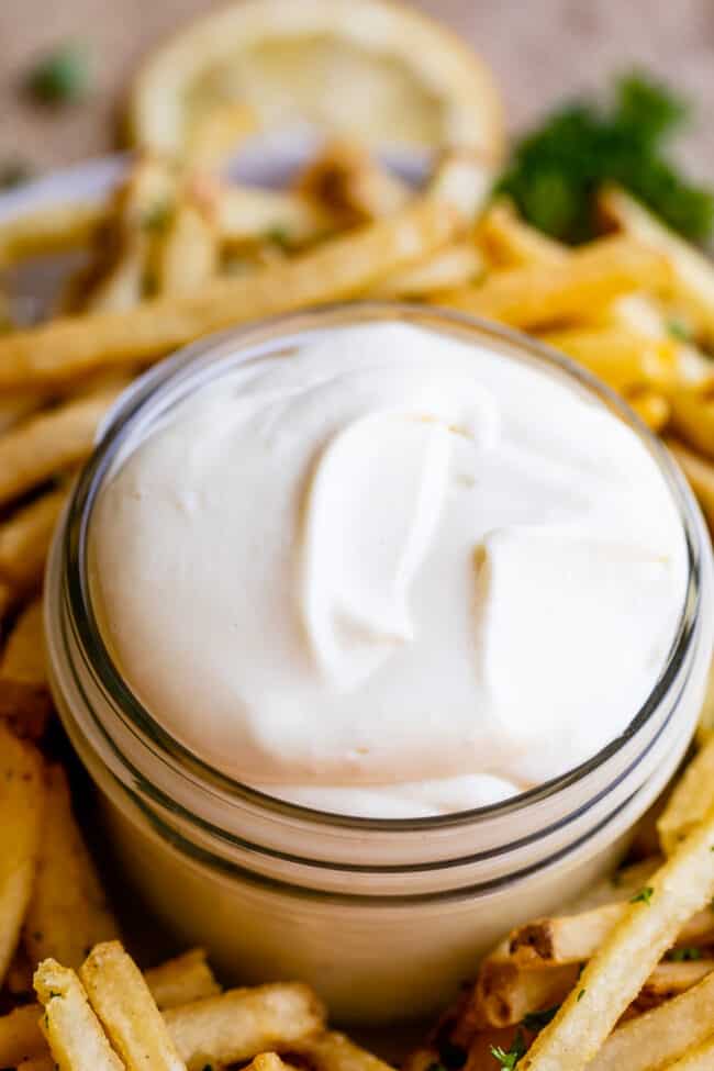 garlic aioli in a jar with fries in the background.