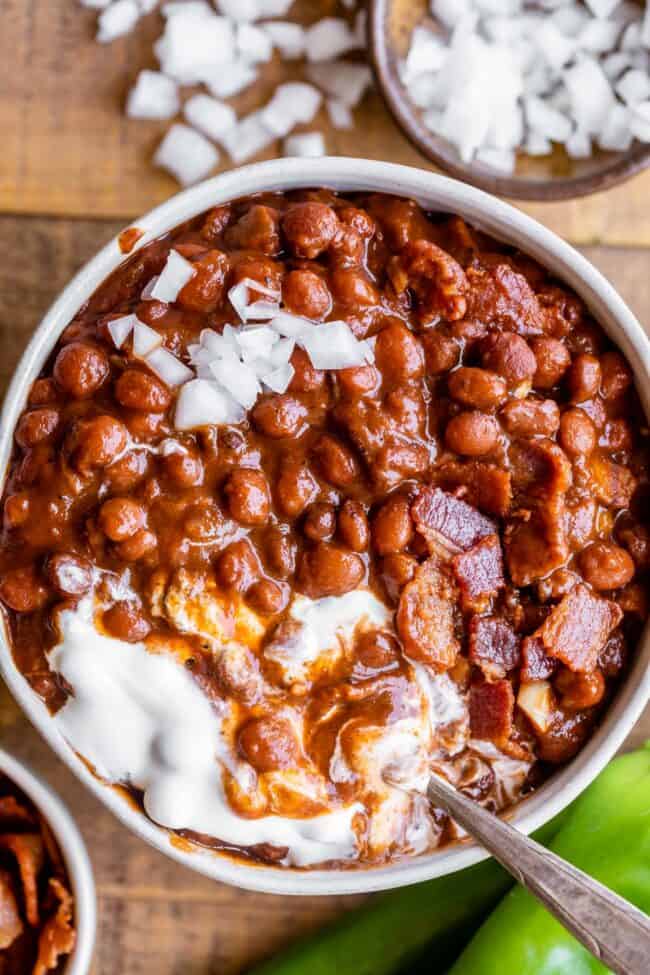 pinquito beans in a bowl with sour cream and chopped onions.