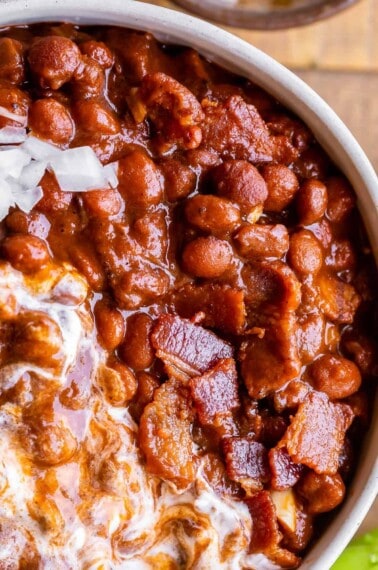 santa maria style beans in a bowl with bacon and sour cream