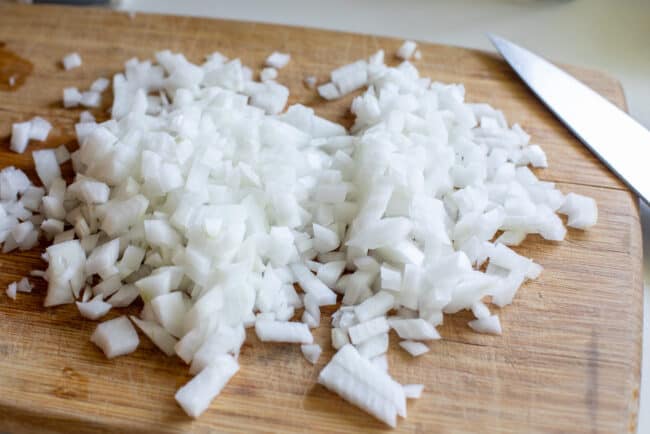chopped white onions on a cutting board.