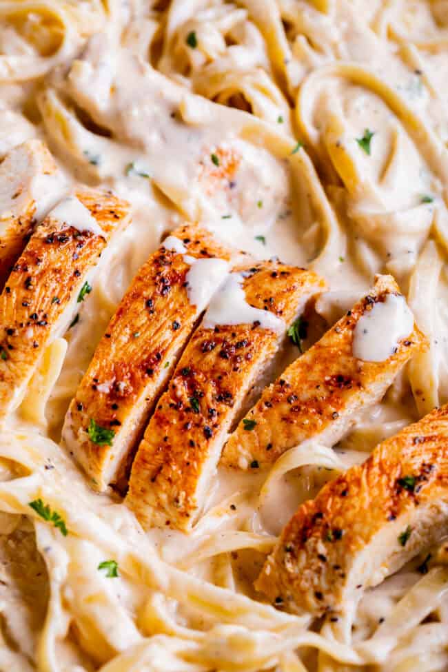 close up picture of sliced chicken in creamy Alfredo sauce.