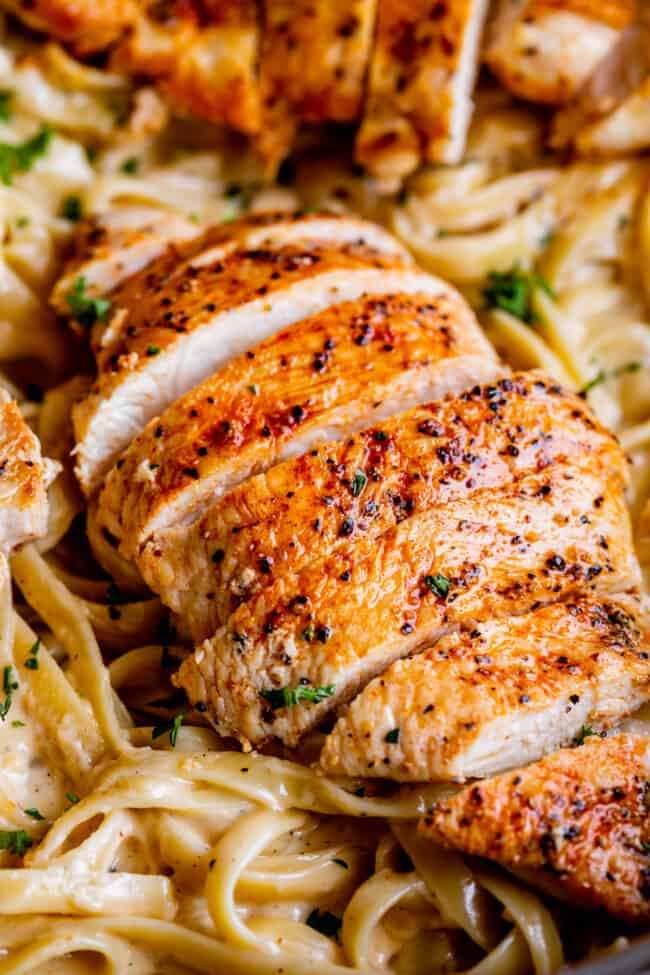 close up of sliced chicken on fettuccine Alfredo.