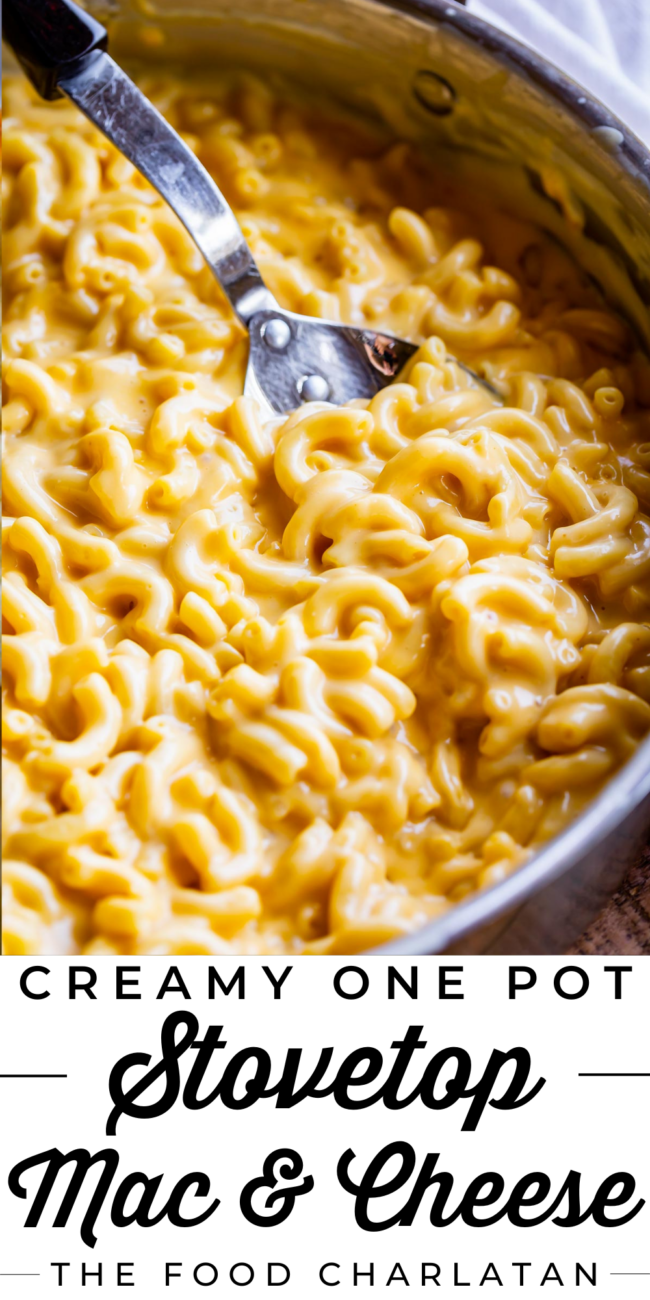 creamy stovetop mac and cheese in a metal pot with a spoon in it.
