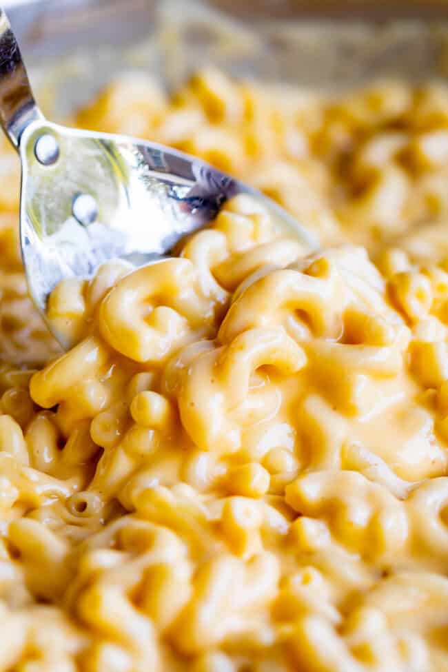 a large spoon lifting creamy mac and cheese.