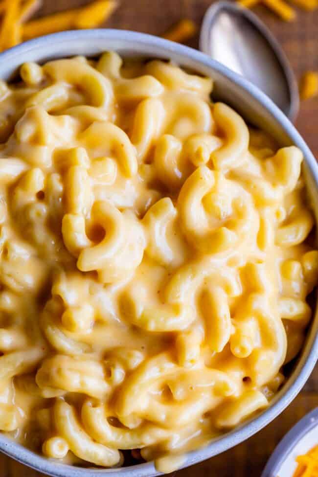 creamy mac and cheese in a bowl with a spoon on the side.