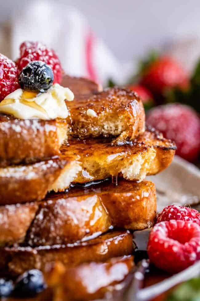 thick and fluffy french toast with butter, syrup, and berries.