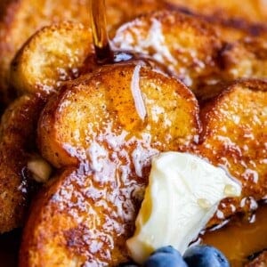 stack of brioche french toast with butter and blueberries and syrup
