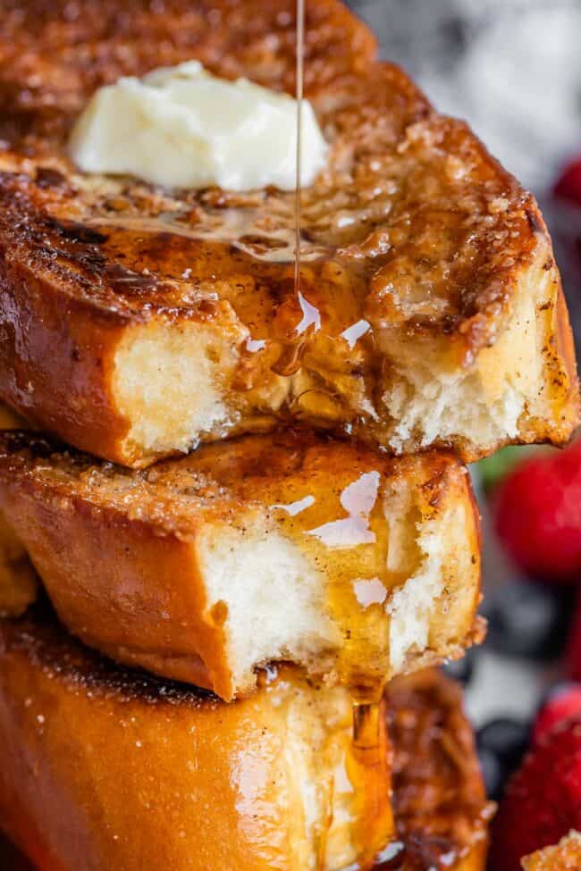 thick sliced challah french toast drizzled with syrup.