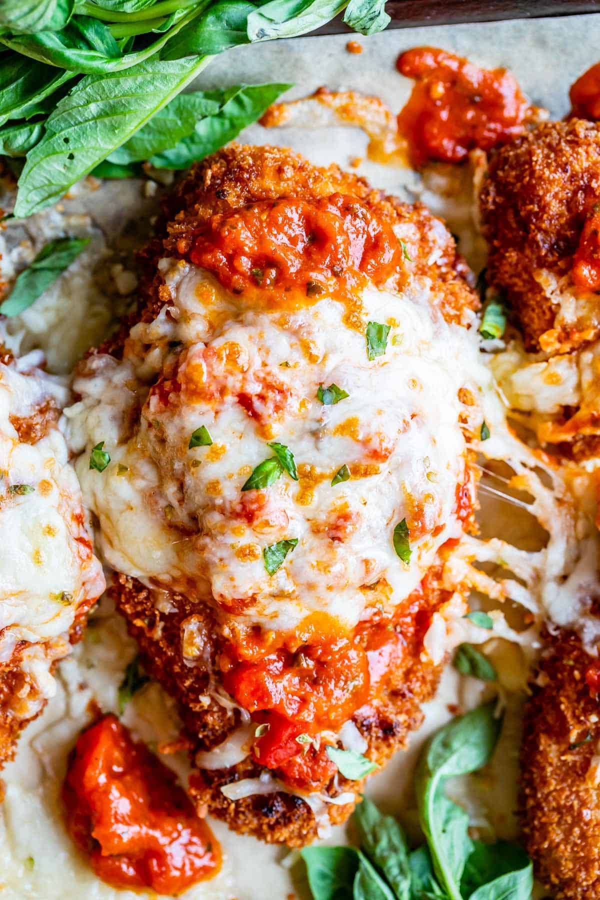 crispy chicken parmesan on a pan with cheese stretch; shot from overhead