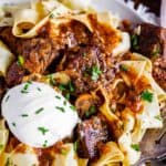 beef stroganoff recipe slow cooker, on a plate with sour cream