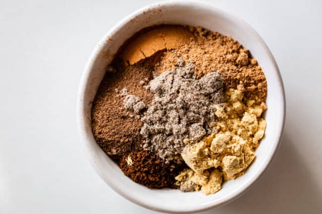 spices including nutmeg, ginger, cloves, allspice, and cardamom in a bowl