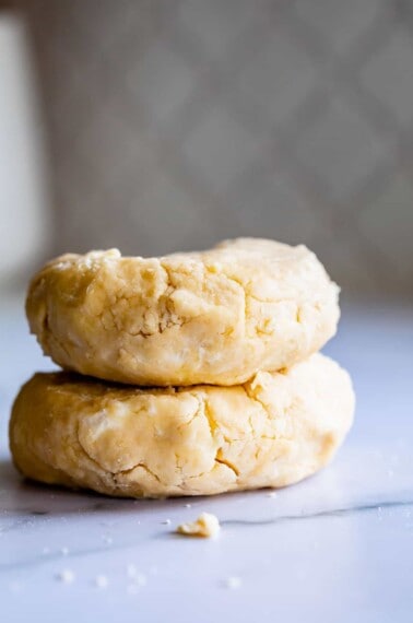 two pie crusts shaped into discs, ready to chill