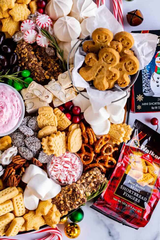 how to make a dessert charcuterie board with shortbread, cranberries, gingerbread, pretzels, candy canes, pecans, meringues