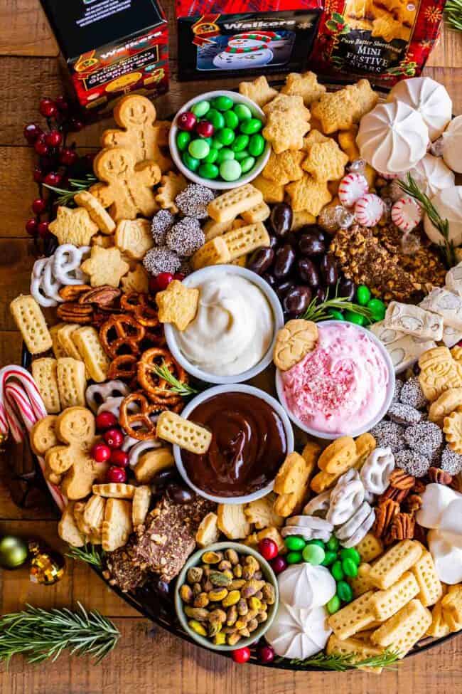 pretzels, dips, shortbread, candy, pecans, nuts, chocolate covered almonds, M&Ms, meringues, toffee, etc on a board.