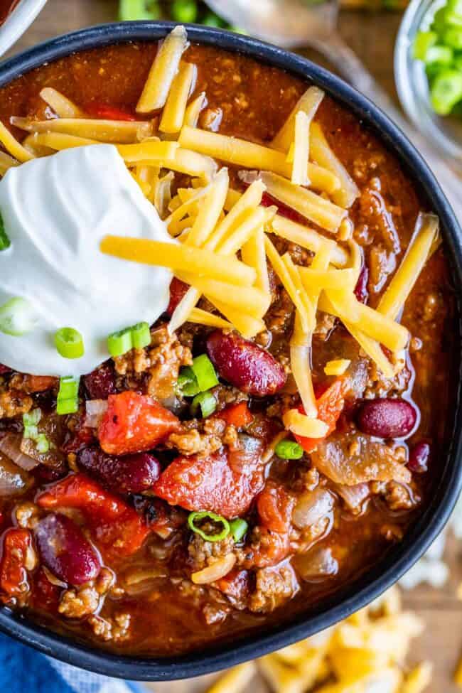 easy chili recipe in a black bowl with cheese and sour cream