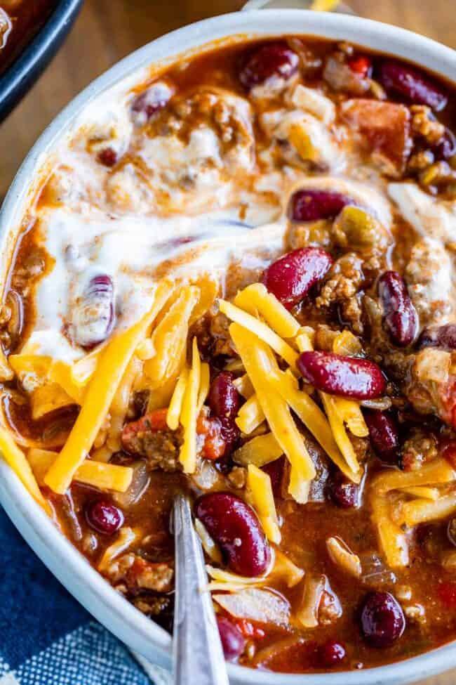 easy chili recipe in a bowl with a spoon and garnishes