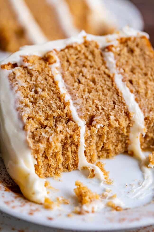 three layer spice cake recipe with cream cheese frosting with bites taken out of it. 