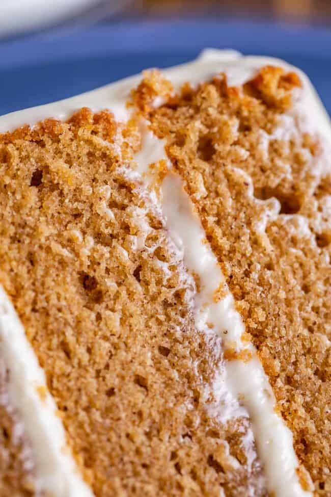 close up photo of layered spice cake with cream cheese frosting. 