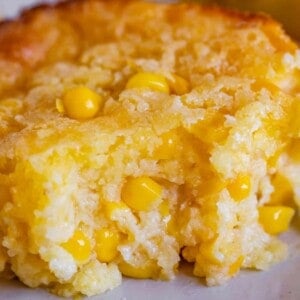 creamed corn casserole on a plate with a bite taken out