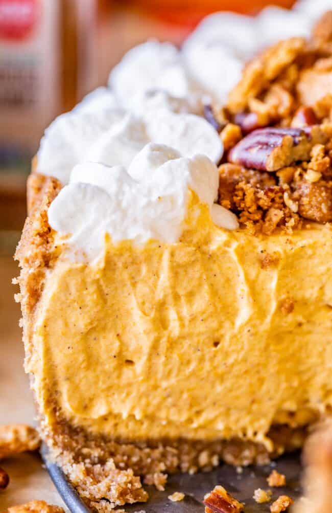 no bake pumpkin cheesecake with whipped cream and pecan crumble, shot from the side.