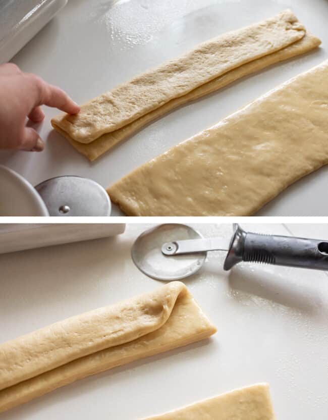 folding buttered dough in half for dinner rolls.