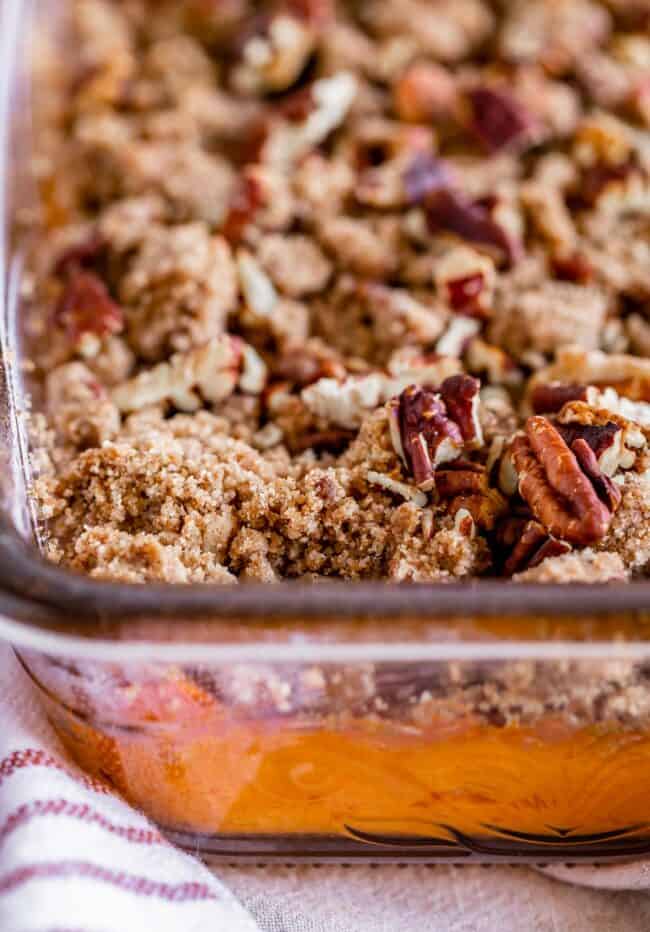 sweet potato casserole with pecan topping in a glass baking dish.
