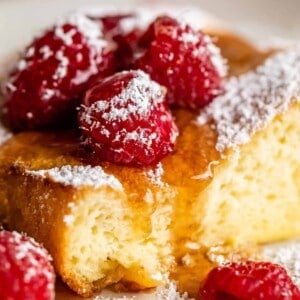 a fluffy german pancake recipe with syrup and raspberries