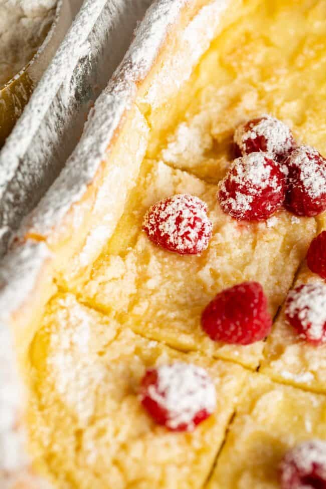 dutch baby german pancakes in pan with raspberries and powdered sugar.