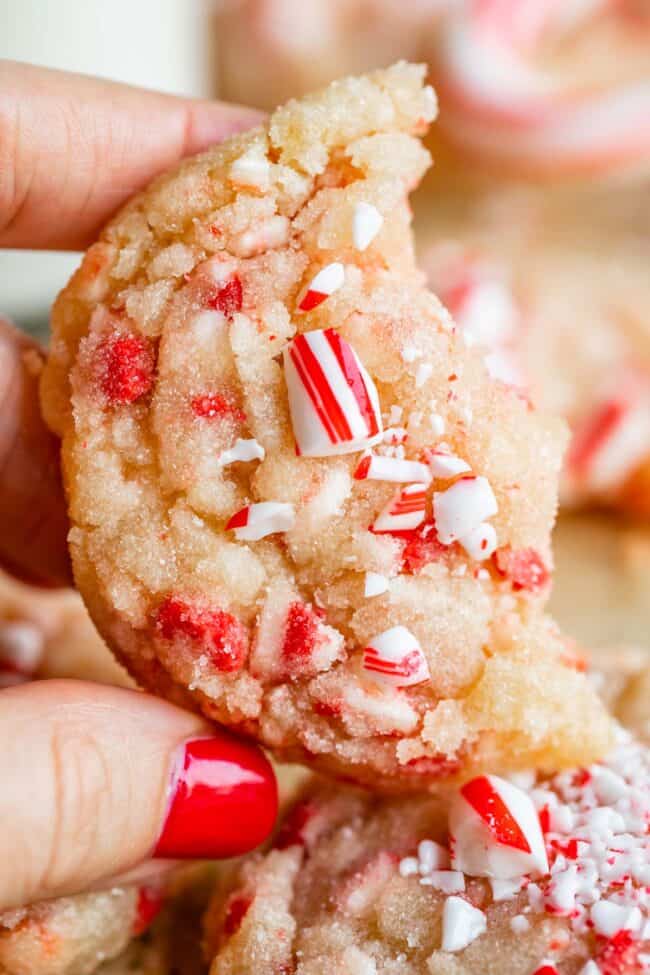 peppermint crunch sugar cookies held in a hand with red nails.