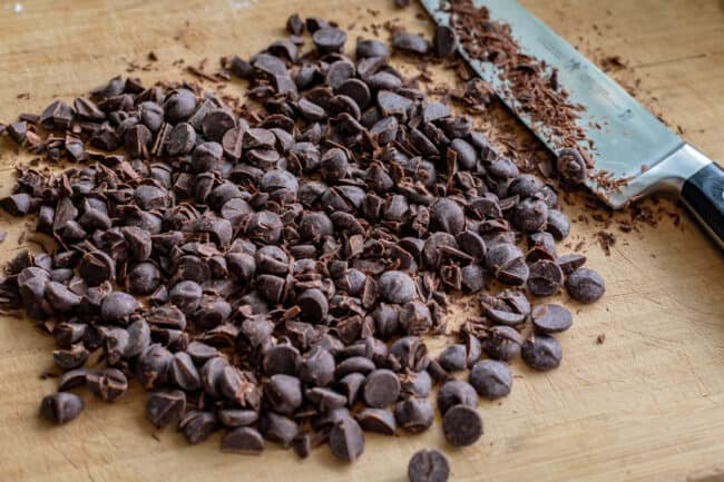 chopped dark chocolate on a cutting board with a knife