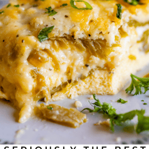 A close-up of a cheesy chile relleno casserole topped with chopped green onions and parsley, featuring a golden, bubbly surface. Text below reads Seriously Good Chile Relleno Casserole - The Food Charlatan.