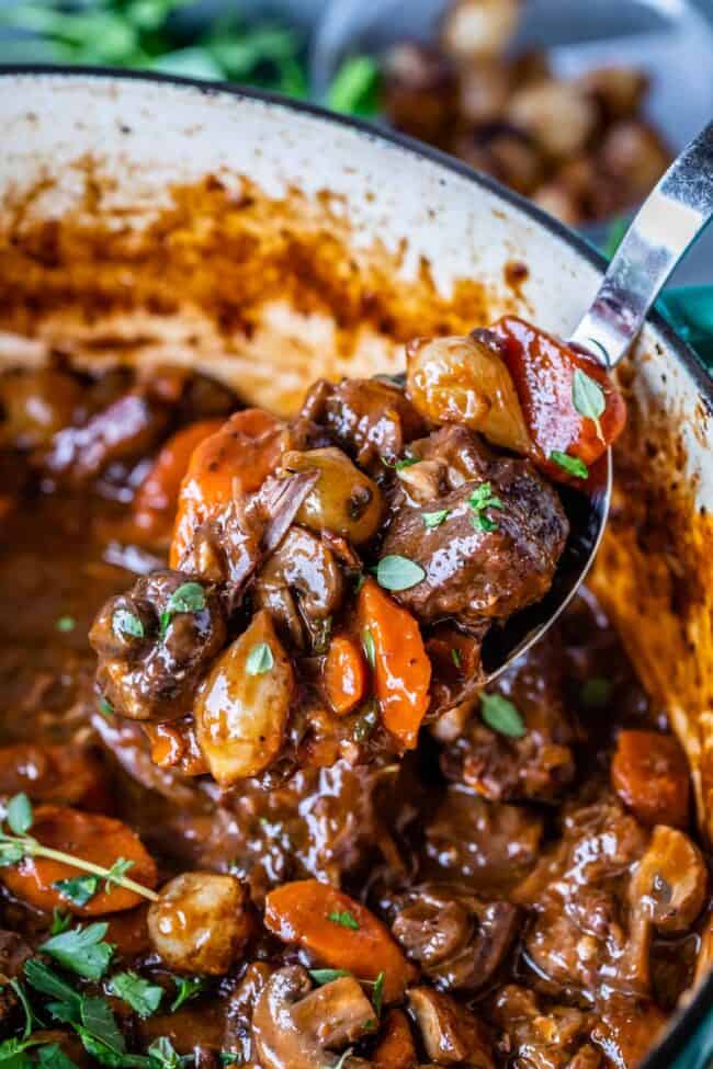 how to make beef bourguignon, in a pot with a spoonful lifted out 