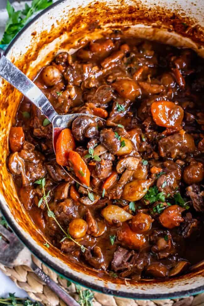 overhead shot of beef bourguignon recipe in a pot with a spoon.