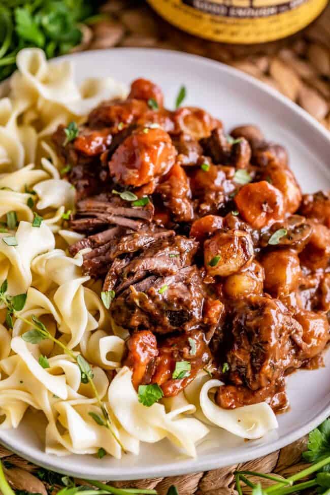 what to serve with beef bourguignon: egg noodles on a plate with the stew