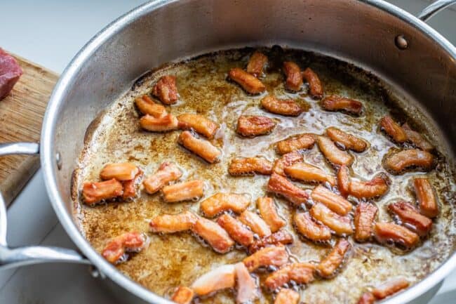 salt pork being fried in a pan for beef bourguignon. 