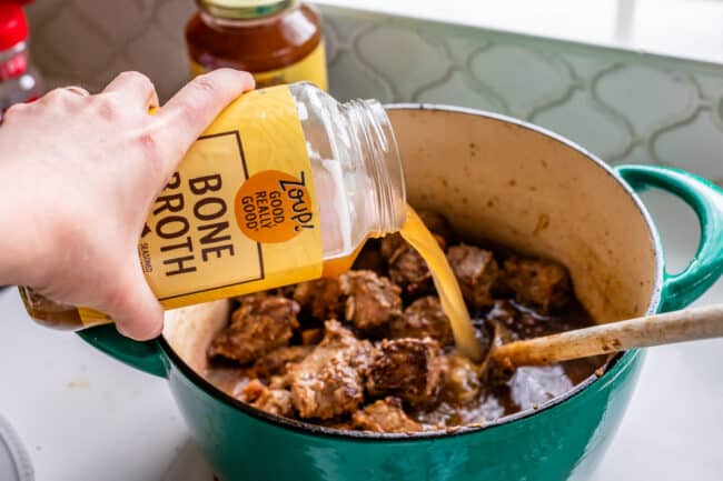 pouring Zoup beef bone broth into a stew.