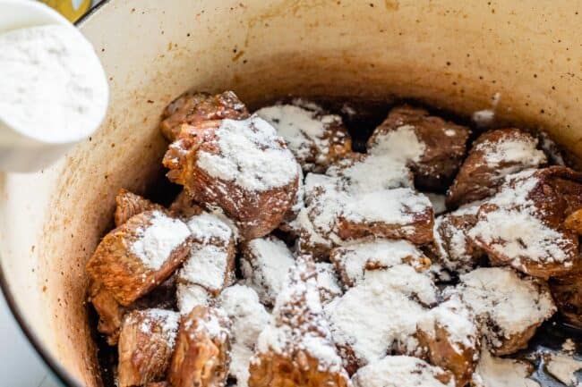 seared beef in a pot, covered in flour