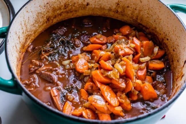 adding sautéed carrots to beef bourguignon.