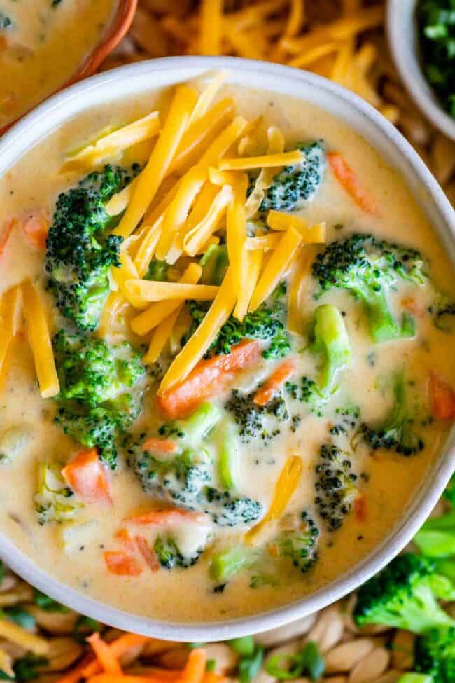 broccoli and cheese soup in a bowl with cheese sprinkled on top.