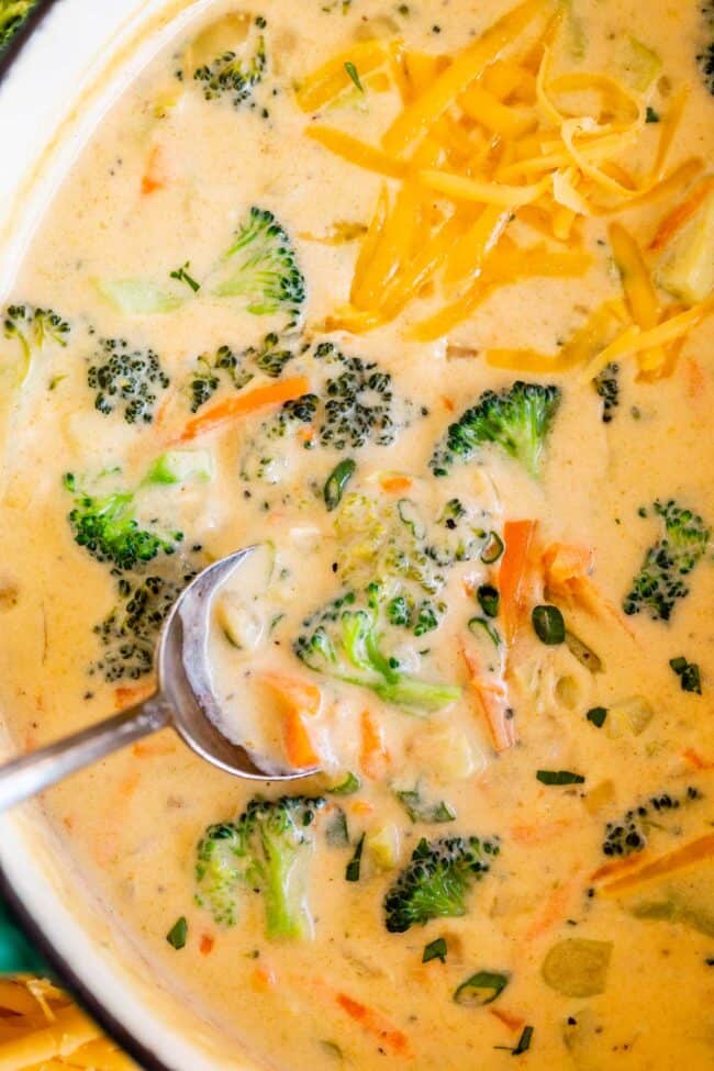 easy broccoli cheese soup in a pot with a silver spoon lifting a bite.