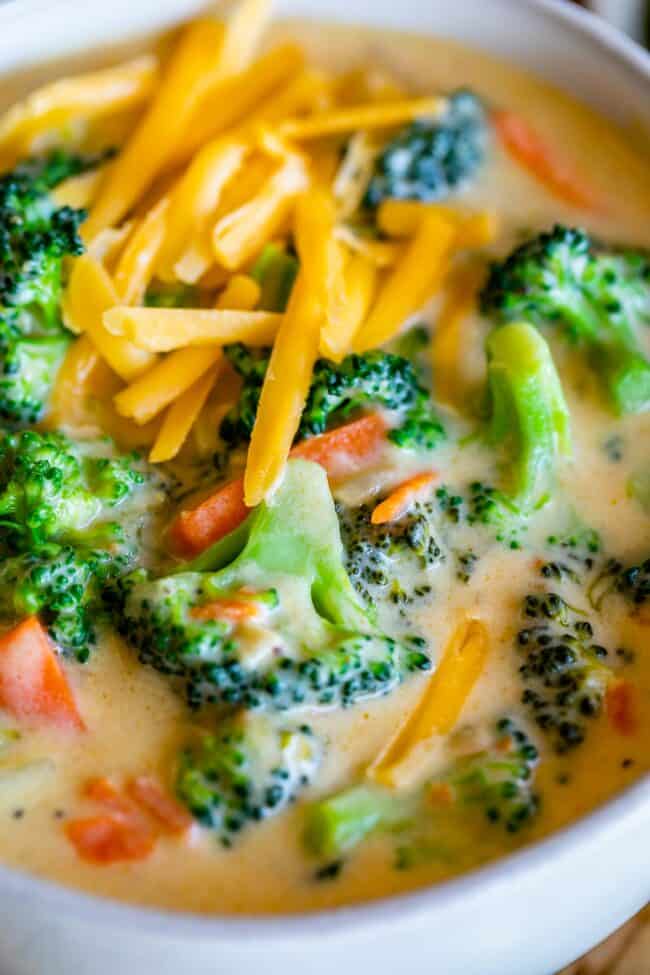 easy broccoli cheese soup in a white bowl, with cheddar cheese