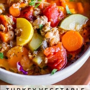 weight loss soup in a white bowl with turkey, yellow squash, zucchini, tomatoes, carrots, celery, etc.