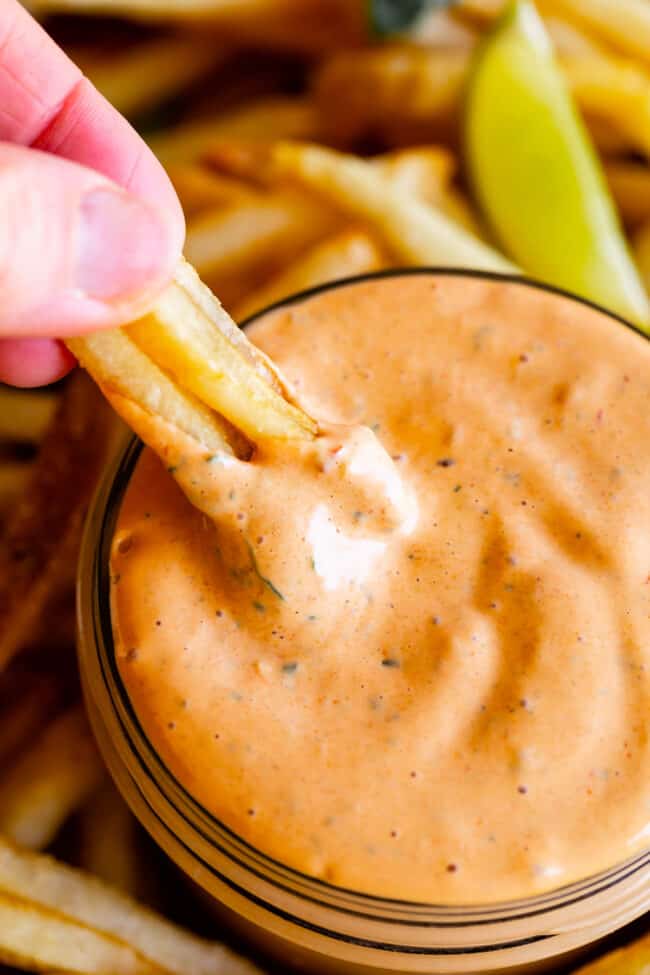 dipping french fries into chipotle mayo sauce.